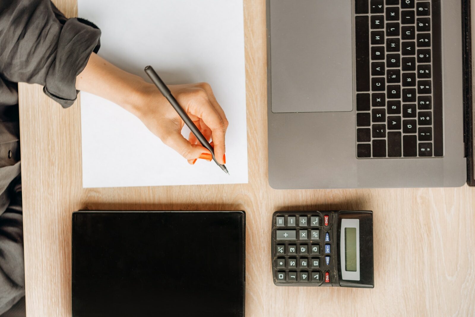 Person Holding a Pen on Top of a Desk