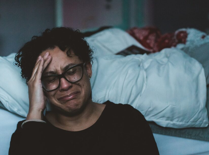 person crying beside bed