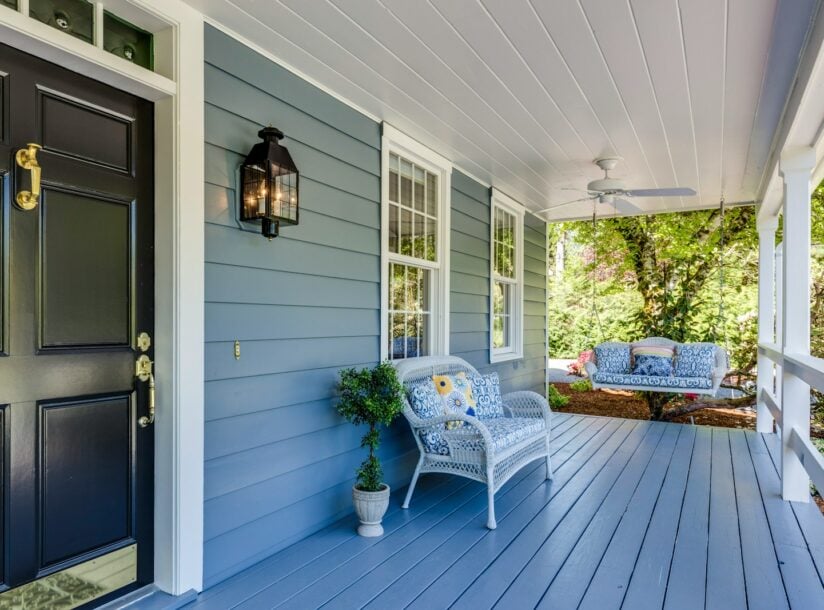 a porch with two chairs and a table on it