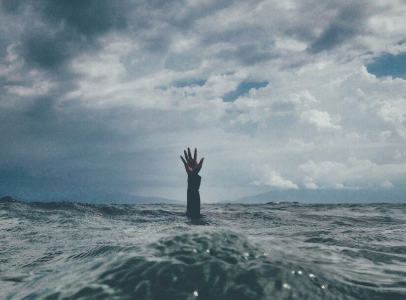 photo of person reach out above the water